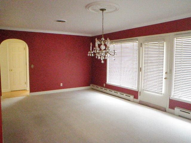 810 13th Ave, Mendota, IL 61342 - spare room with a baseboard heating unit, a baseboard radiator, ornamental molding, carpet flooring, and a chandelier