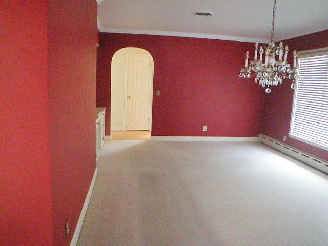 810 13th Ave, Mendota, IL 61342 - spare room with a chandelier, arched walkways, ornamental molding, a baseboard heating unit, and carpet flooring