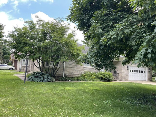 810 13th Ave, Mendota, IL 61342 - view of side of home with stone siding, a lawn, and a garage