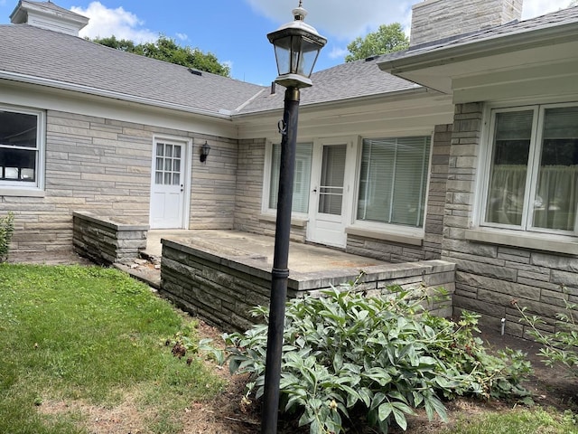 810 13th Ave, Mendota, IL 61342 - view of home's exterior featuring a chimney, stone siding, and roof with shingles