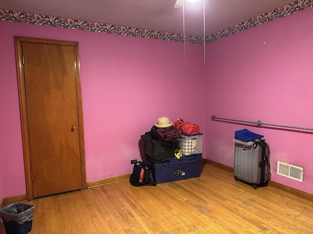 miscellaneous room featuring wood-type flooring, baseboards, and visible vents