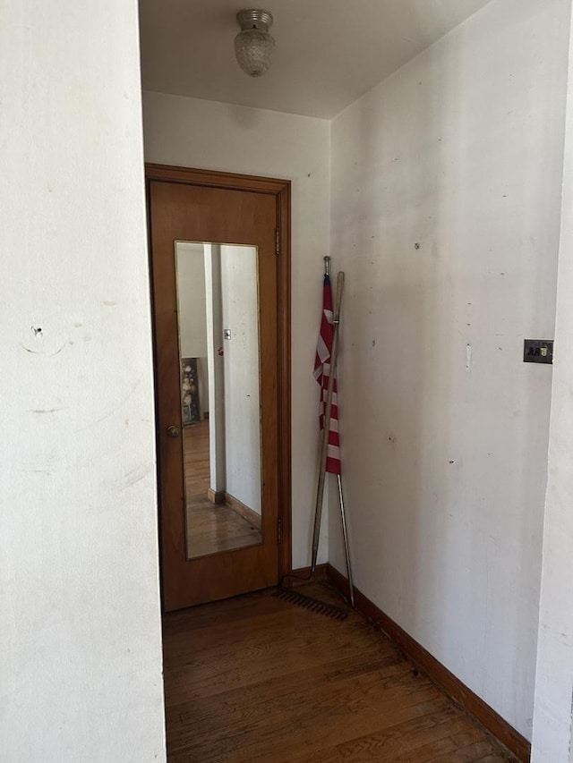 hallway featuring baseboards and wood finished floors