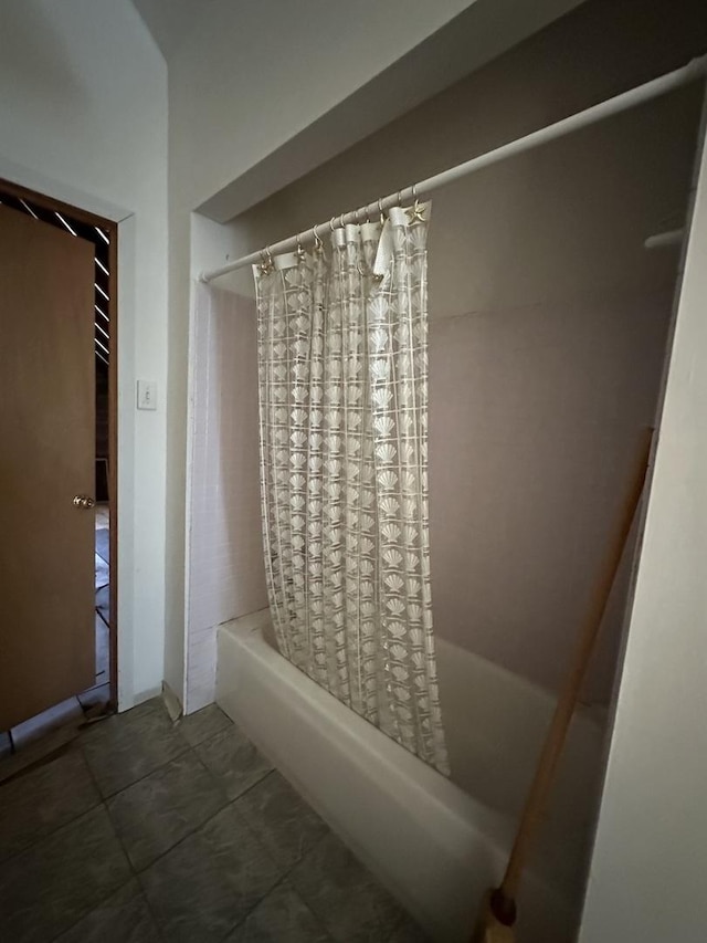 bathroom with shower / bath combo with shower curtain and tile patterned flooring