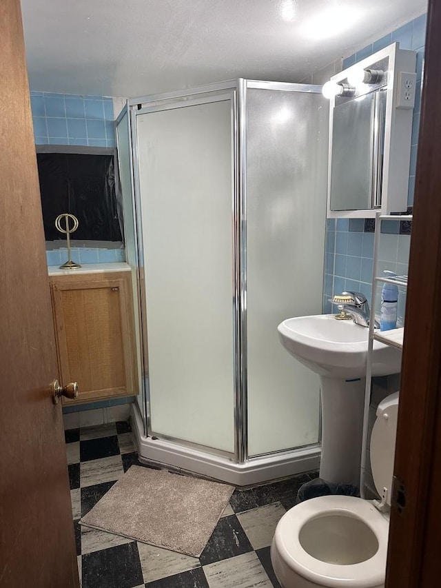 bathroom with a shower stall, tile patterned floors, tasteful backsplash, and toilet