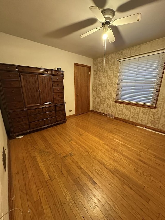 unfurnished bedroom with baseboards, light wood-type flooring, and visible vents