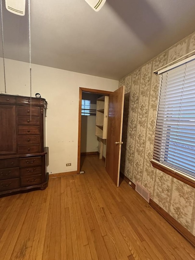 bedroom with baseboards, visible vents, a closet, and light wood-type flooring