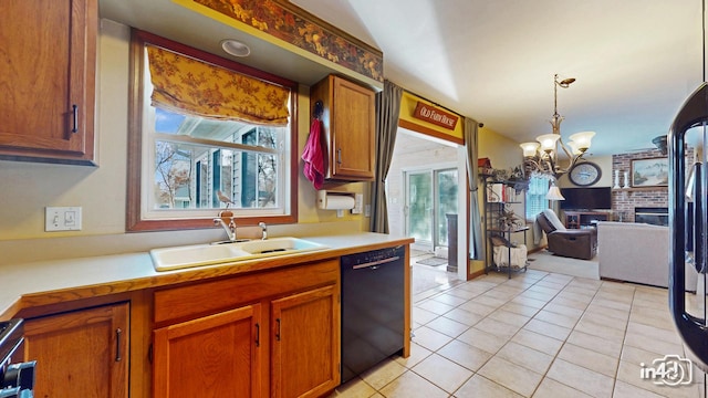 kitchen featuring an inviting chandelier, a sink, black dishwasher, light tile patterned flooring, and light countertops