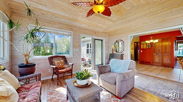 living room with high vaulted ceiling, wooden walls, and plenty of natural light