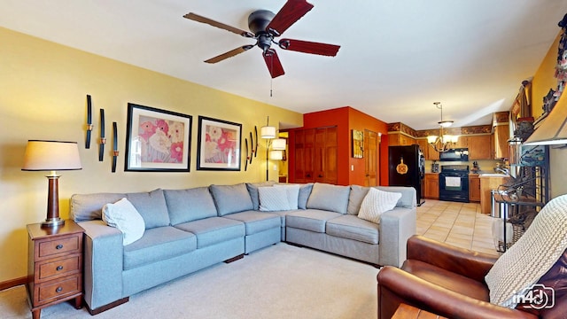 living room featuring ceiling fan with notable chandelier and light colored carpet