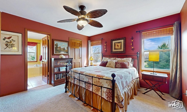 bedroom with connected bathroom, a ceiling fan, and light colored carpet
