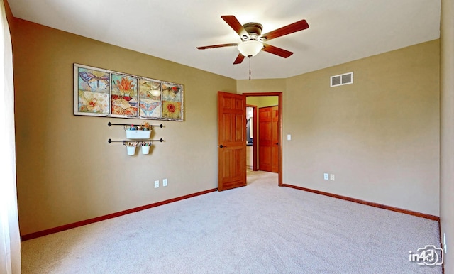empty room featuring visible vents, a ceiling fan, baseboards, and light carpet