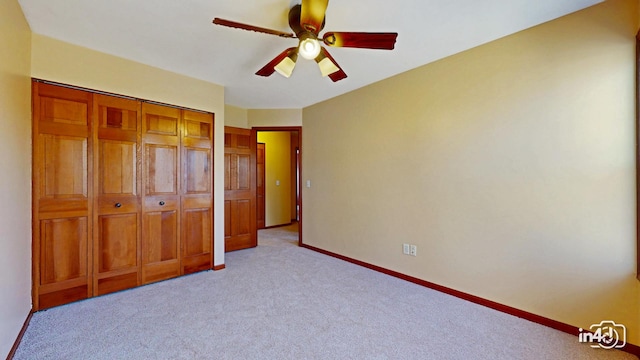 unfurnished bedroom featuring baseboards, a ceiling fan, light carpet, and a closet