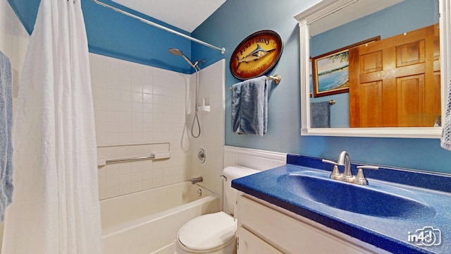 full bathroom featuring toilet, shower / bath combo, wainscoting, and vanity