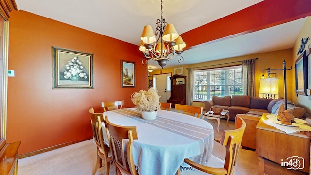 dining room with baseboards, a notable chandelier, and light colored carpet