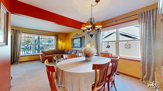 dining area with baseboards, a notable chandelier, and light colored carpet