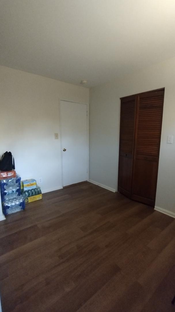 unfurnished bedroom featuring a closet, baseboards, and wood finished floors