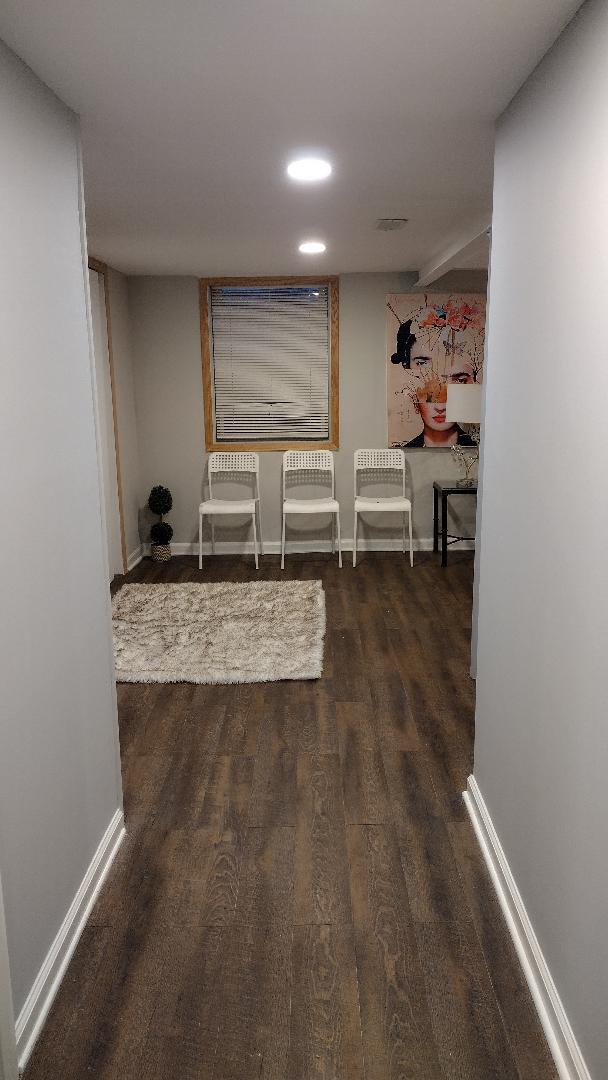 corridor with baseboards and wood finished floors