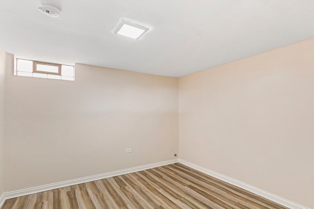 spare room with baseboards and light wood-style floors