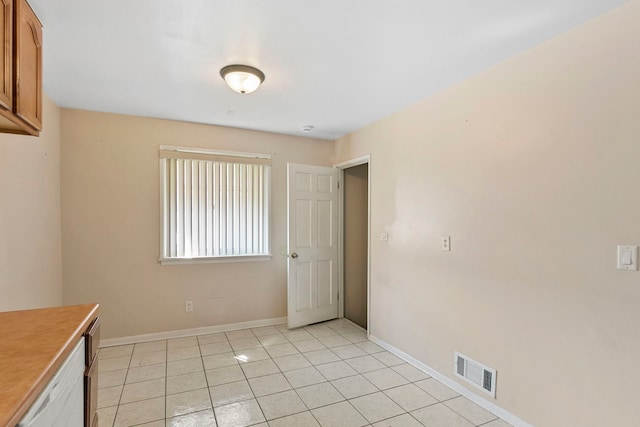 unfurnished room with light tile patterned flooring, visible vents, and baseboards