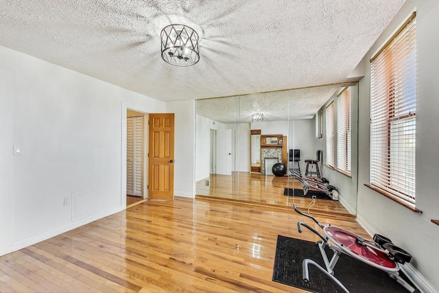 4364 S Oakenwald Ave, Chicago, IL 60653 - workout room featuring wood-type flooring, baseboards, a fireplace, and a textured ceiling