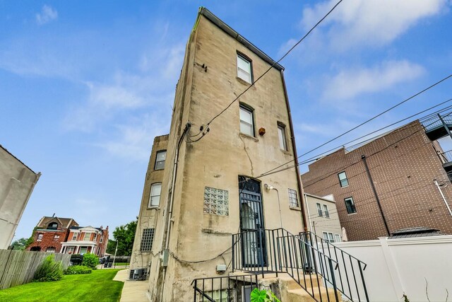 4364 S Oakenwald Ave, Chicago, IL 60653 - rear view of property with a lawn, cooling unit, fence, and stucco siding