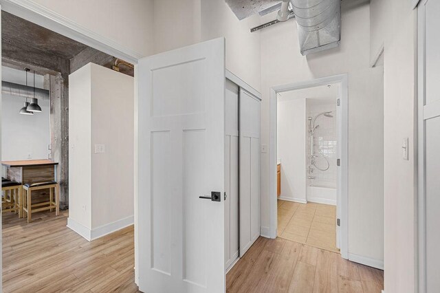 hall featuring baseboards and light wood-type flooring
