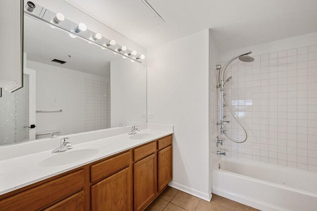bathroom with double vanity, a sink, tile patterned floors, and shower / bathtub combination
