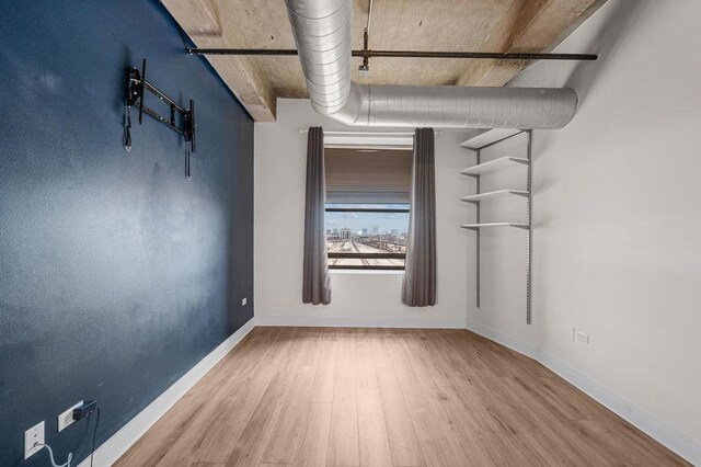 unfurnished room featuring baseboards and wood finished floors