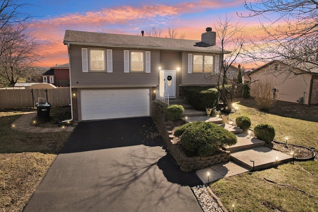 5621 Fernwood Ct, Matteson, IL 60443 - raised ranch featuring asphalt driveway, a garage, and a chimney
