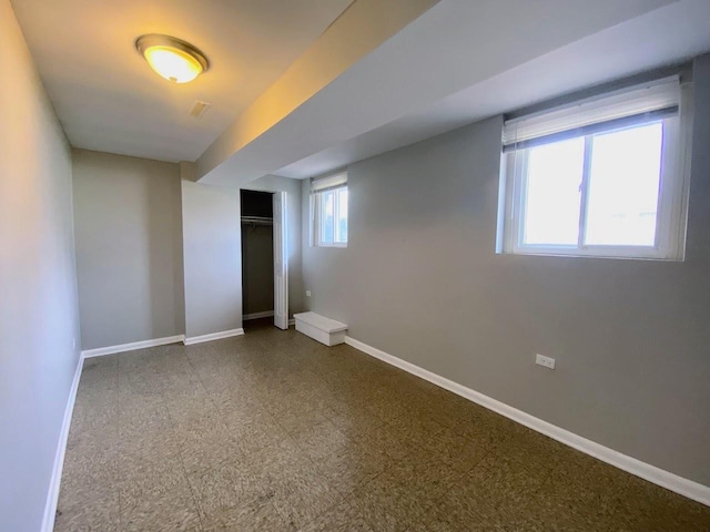below grade area with baseboards and tile patterned floors