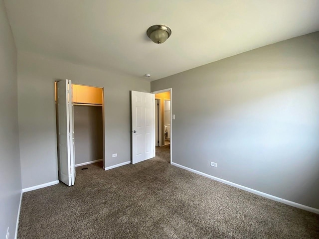 unfurnished bedroom featuring baseboards, a closet, and dark colored carpet