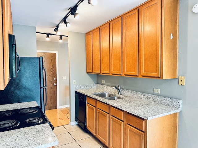 kitchen with track lighting, black appliances, light tile patterned flooring, a sink, and brown cabinets