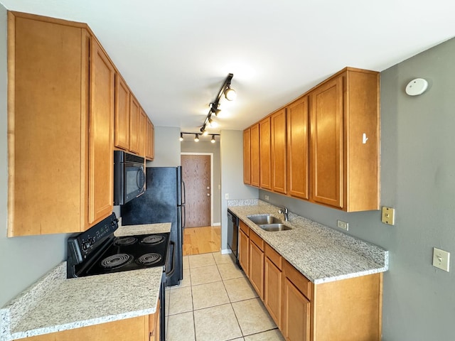 kitchen with light countertops, light tile patterned floors, a sink, and black appliances