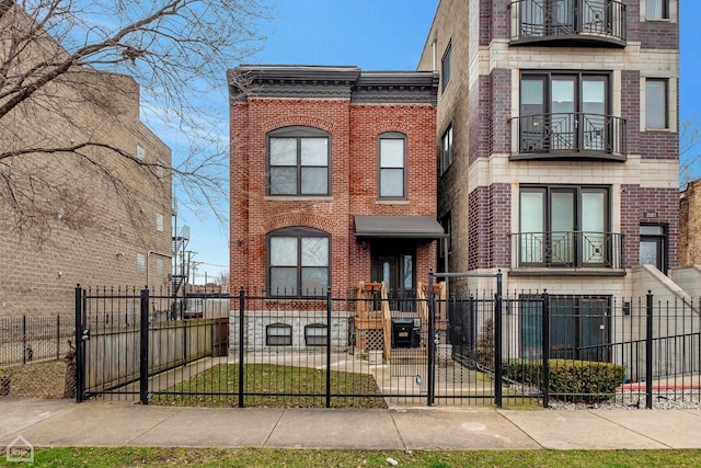view of front of property featuring brick siding, a balcony, and a fenced front yard