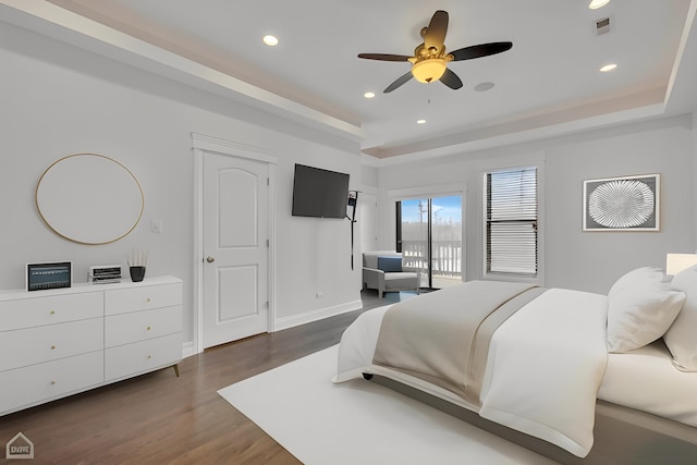 bedroom featuring baseboards, recessed lighting, dark wood-type flooring, visible vents, and a raised ceiling