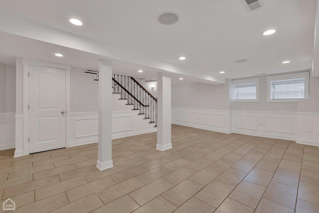 below grade area with visible vents, light tile patterned floors, a decorative wall, recessed lighting, and stairs