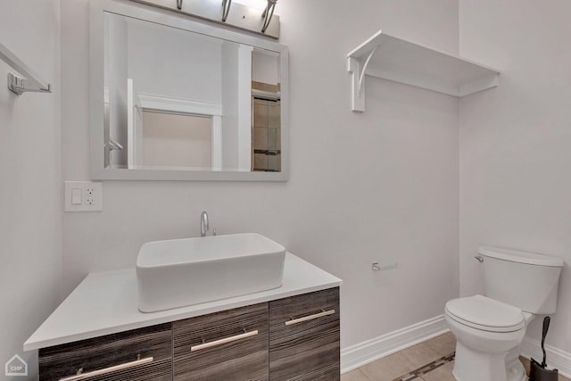 bathroom featuring vanity, baseboards, and toilet