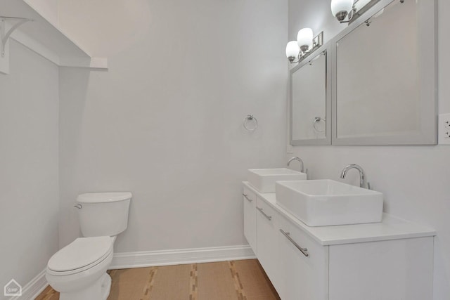 bathroom featuring a sink, baseboards, and wood finished floors