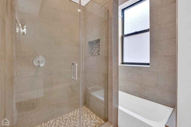 bathroom with a stall shower and a bathtub
