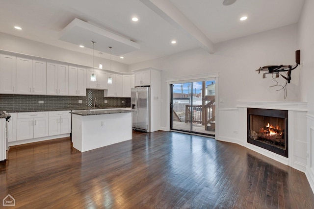 kitchen with stainless steel fridge with ice dispenser, tasteful backsplash, beamed ceiling, dark wood finished floors, and a sink