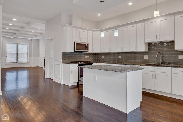 kitchen featuring appliances with stainless steel finishes, dark wood-style flooring, beam ceiling, coffered ceiling, and a sink