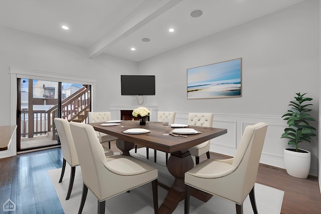 dining area with recessed lighting, a wainscoted wall, beam ceiling, a decorative wall, and wood finished floors