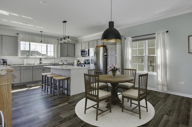 dining space with dark wood-type flooring, ornamental molding, recessed lighting, and baseboards