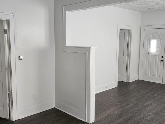 interior space with dark wood-style floors, baseboards, and a textured ceiling