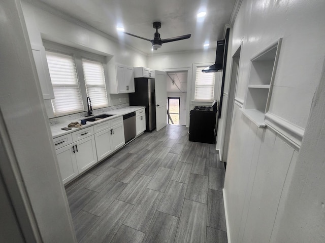 kitchen featuring light countertops, stainless steel appliances, a sink, ceiling fan, and white cabinets