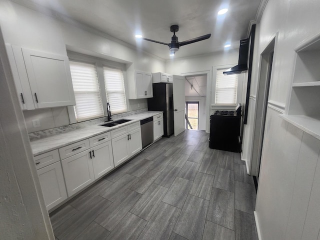 kitchen with light countertops, stainless steel appliances, a sink, white cabinets, and a ceiling fan