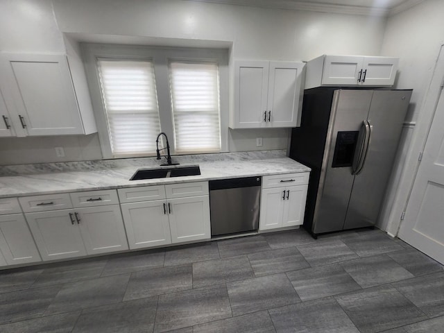 kitchen featuring white cabinetry, light stone counters, a sink, and stainless steel appliances