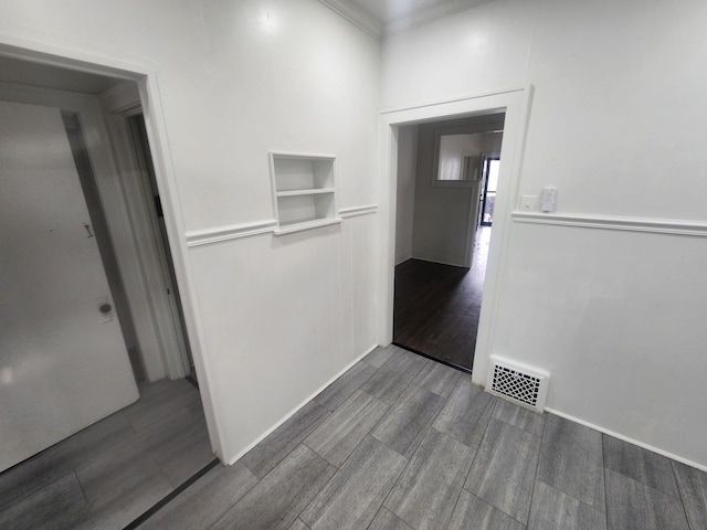 corridor with visible vents, wood finish floors, and crown molding