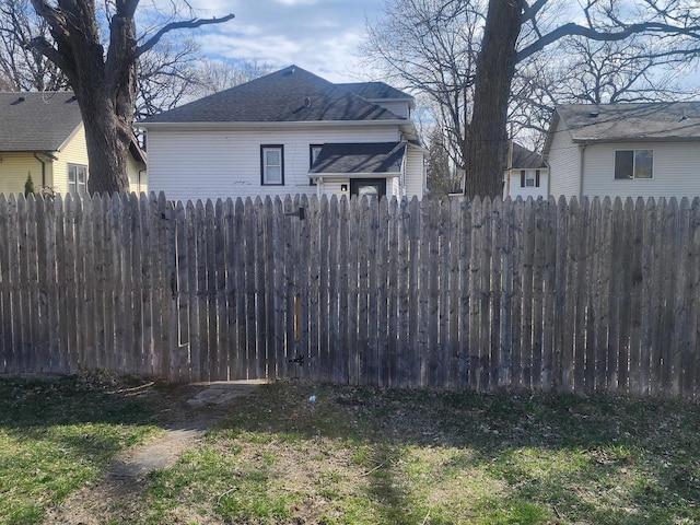 view of property exterior with a shingled roof and fence