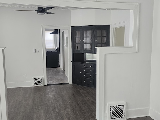 corridor featuring baseboards, visible vents, and dark wood-type flooring